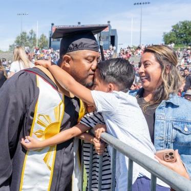 A graduate kissing his son