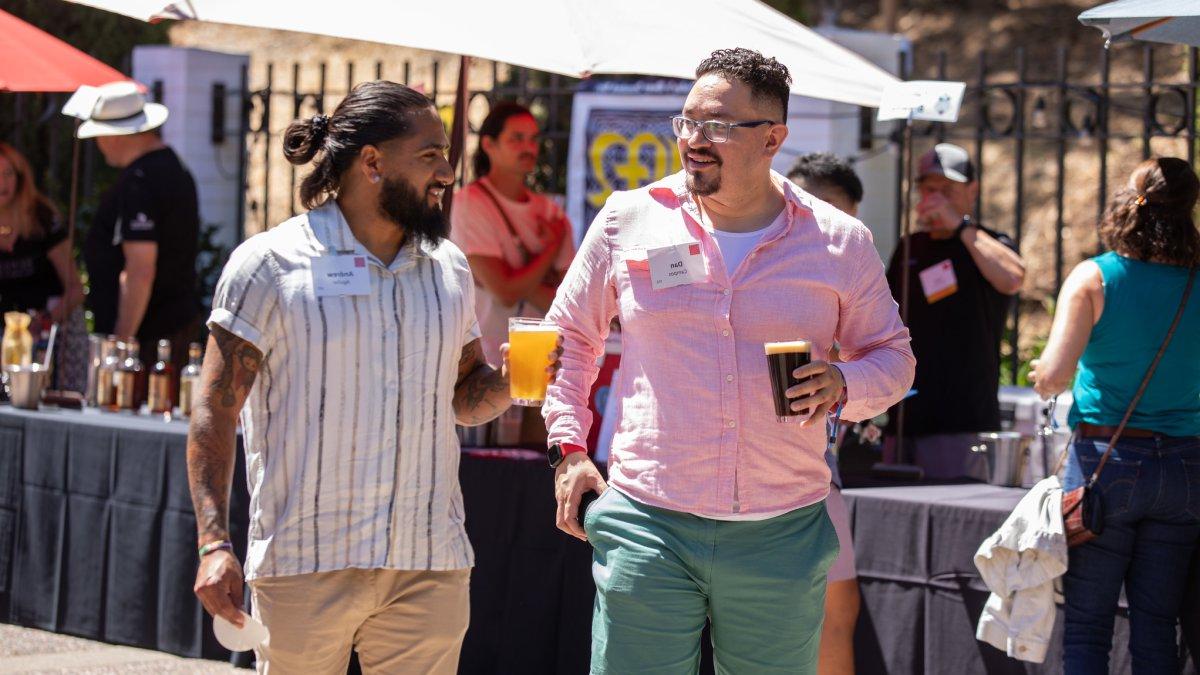 Two young men hold beers